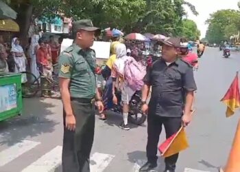 Babinsa Tembok Dukuh Bantu Siswa Sekolah Menyeberang Jalan