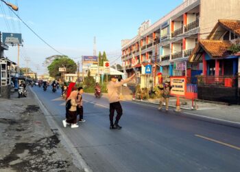 Wujud Kepedulian, Polisi Bantu Anak-Anak Sekolah Menyeberang Jalan