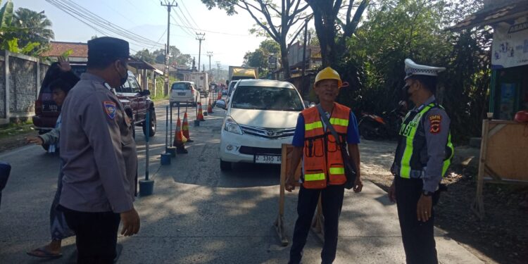 Personil Unit Lantas Polsek Sukalarang Atur Lalu Lintas di Lokasi Perbaikan Jalan